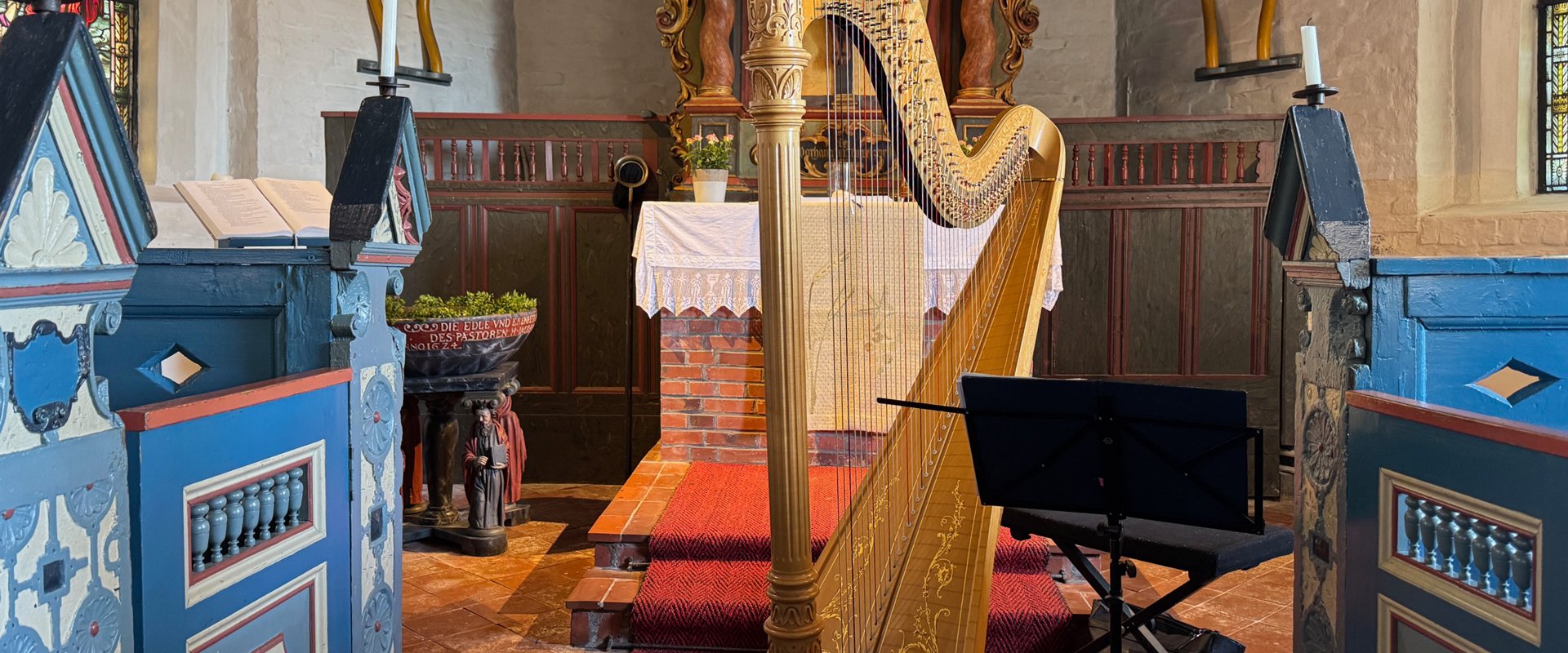 Innenraum der Halligkirche Hooge mit einer Harfe vor dem Altarraum